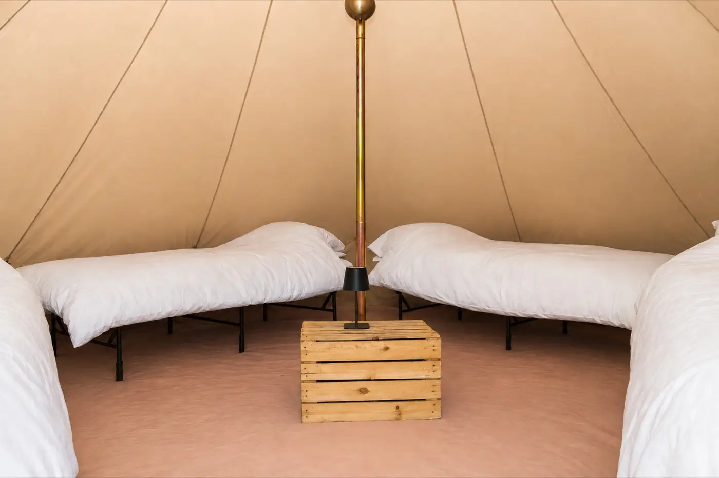 Four real beds with white bedding around an apple crate