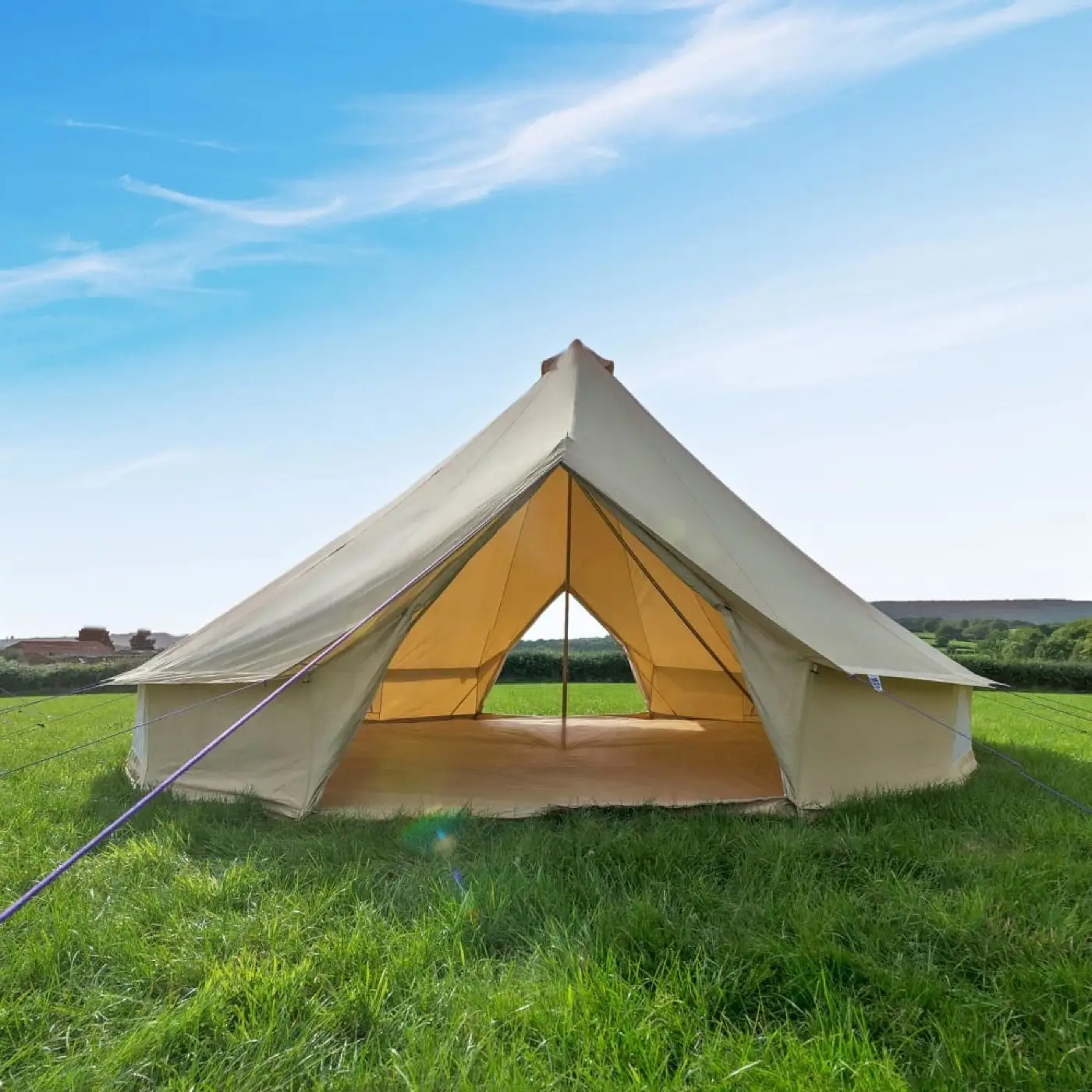 Pitched bell tent with the door open and a bare groundsheet inside