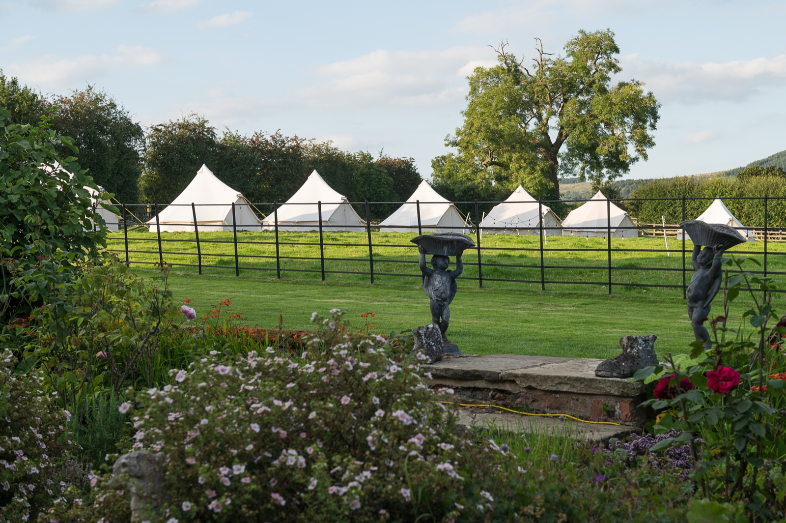 Bell tents pitched in a garden beside the house