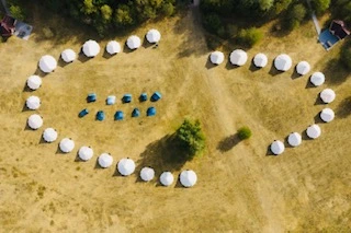 The Wild in the Woods camping field from directly above, tents in a horseshoe around an open middle