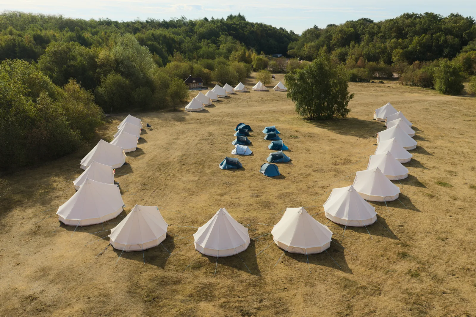 Aerial view of the Wild in the Woods camping field with bell tents arranged in a horseshoe